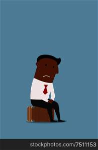 Thoughtful unemployed african american businessman sitting on the suitcase after job loss and worrying about future. Unemployment, jobless, redundancy or job loss business concept. Frustrated businessman lost his job