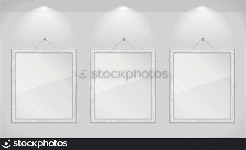 Three white wooden frames on gray wall