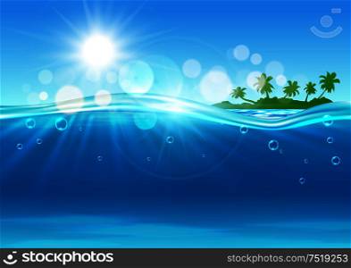 Tropical island background with marine landscape of over and under water surface with green silhouette of island with palms at the horizon and blue waves with sun and flare spots.. Tropical island in the ocean for background design