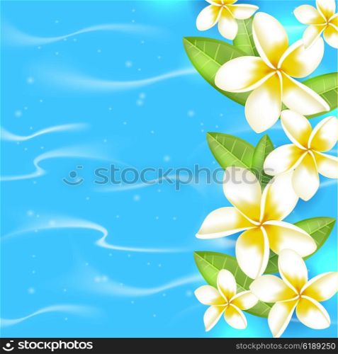 Tropical summer background with flowers and leaves in blue water. Tropical flowers on a blue background.