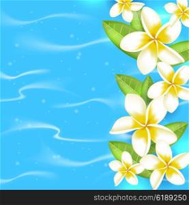 Tropical summer background with flowers and leaves in blue water. Tropical flowers on a blue background.
