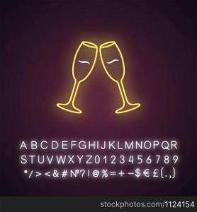 Two clinking wine glasses yellow neon light icon. Champagne flutes. Glassfuls of alcohol drink. Wine service. Celebration. Glowing sign with alphabet, numbers and symbols. Vector isolated illustration