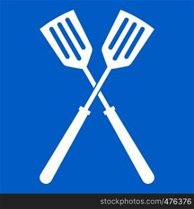 Two metal spatulas icon white isolated on blue background vector illustration. Two metal spatulas icon white
