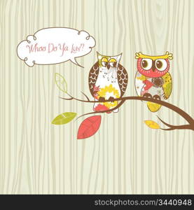 Two pretty owls sitting on the branch.