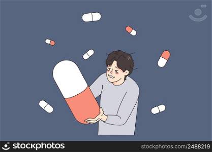 Unhappy stressed man suffer from drug addiction hold huge pill. Upset unhealthy guy struggle with depression addicted to medication and tablets. Medicine and healthcare. Vector illustration. . Stressed man addicted to pills and medications 
