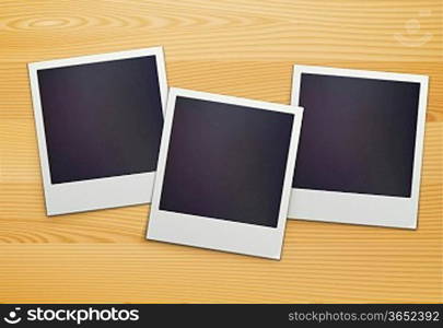 Vector illustration of three blank retro polaroid photo frames over wooden background