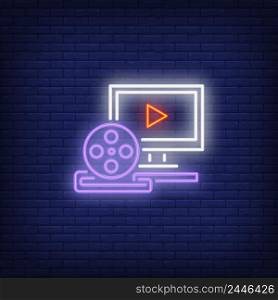 Video production neon sign. Luminous signboard with computer and film reel. Night bright advertisement. Vector illustration in neon style for footage production, video editing, cinematography