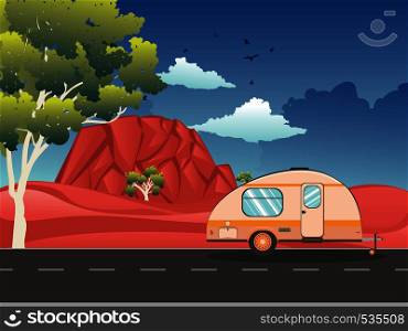 Vintage camping trailer on the road in the red desert landscape.