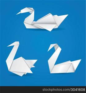 White folded paper swans on blue background.. Origami swans
