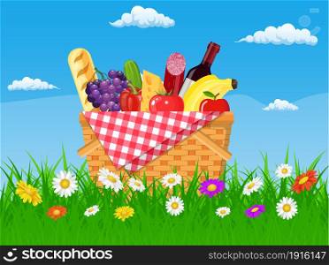 WIcker picnic basket full of products. Wine, sausage, bacon and cheese, apple, tomato, cucumber. Grass, flowers, sky with clouds. Vector illustration in flat style. WIcker picnic basket full of products.