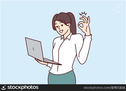 Woman CEO of company stands with laptop in hands and shows OK gesture, giving consent to plan proposed by employees. Businesswoman performs duties of CEO director and looks at screen smiling. Business woman CEO of company stands with laptop in hands and shows OKAY gesture