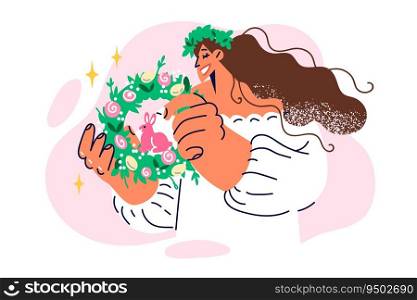 Woman holds easter wreath of spring herbs with rabbit and colorful eggs for festive ritual. Catholic girl with wide smile demonstrates easter attributes to decorate house or gifts to relatives. Woman holds easter wreath of spring herbs with rabbit and colorful eggs for festive ritual