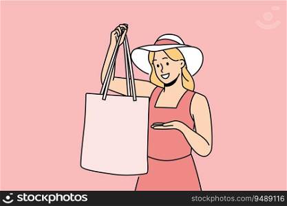Woman holds textile bag recommending to refuse plastic disposable packages for shopping. Fashionable girl in hats demonstrates rag bag for comfortable visit to supermarket and care for nature.. Woman holds textile bag recommending to refuse plastic disposable packages for shopping