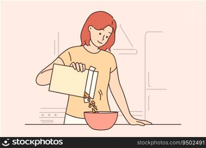 Woman is eating breakfast with cornflakes and holding box of muesli standing near kitchen table. Girl prepares healthy breakfast to refresh herself before going to work or university. Woman is eating breakfast with cornflakes and holding box of muesli standing near kitchen table