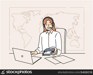 Woman manager of travel agency sits at office desk and holds passport with visas and plane tickets. Tour operator company representative in headphones near giant map of world helps to travel. Woman manager of travel agency sits at office desk and holds passport with visas and plane tickets