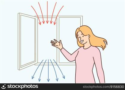Woman points to open window recommending regular airing of apartment for air recirculation. Girl enjoys fresh air after airing house resulting in absence of carbon dioxide in room and good health . Woman points to open window recommending regular airing of apartment for air recirculation