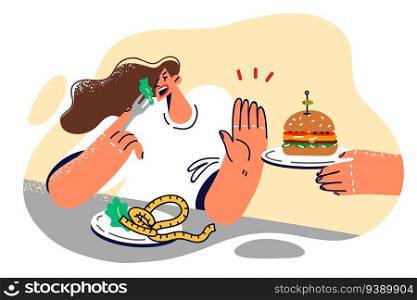 Woman refuses hamburger and eats healthy food, wanting to get rid of excess weight and lead healthy lifestyle. Girl with plate filled with salad makes stop gesture refusing to eat fast food. Woman refuses hamburger and eats healthy food, wanting to get rid of excess weight