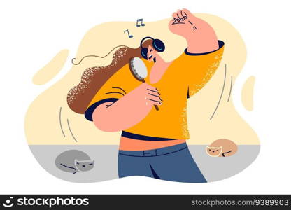 Woman sing using hairbrush instead of microphone and listening to music on headphones imagining attending karaoke or performing on stage. Young girl fun and sings songs of favorite rock group. Woman sing using hairbrush instead of microphone and listening to music on headphones