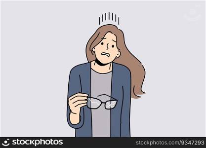 Woman with broken glasses in hands makes confused face not knowing how to solve vision problem. Careless girl holds glasses with cracked glass and needs to go to optometrist or buy contact lenses. Woman with broken glasses in hands makes confused face not knowing how to solve vision problem
