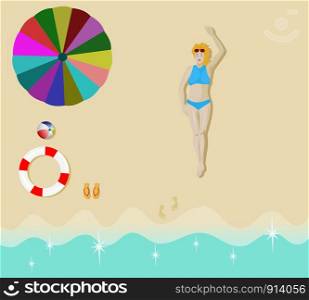 Women in a blue bikini sunbathing on the sand beach with umbrellas, balls, rubber rings and sandals placed beside.