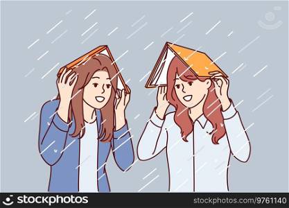 Women take shelter from rain under books and smile, rejoicing at onset of autumn season. Happy girls cover heads with textbooks to avoid getting wet during heavy rain or spring storm. Women take shelter from rain under books and smile, rejoicing at onset of autumn season