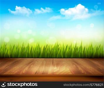 Wooden deck in front of green grass and blue sky background.