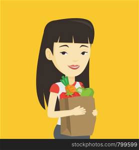 Young asian woman carrying grocery shopping bag with vegetables. Woman holding grocery shopping bag with healthy food. Woman with grocery shopping bag. Vector flat design illustration. Square layout.. Happy woman holding grocery shopping bag.