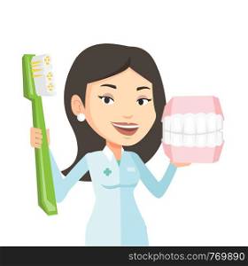 Young caucasian dentist holding dental jaw model and toothbrush in hands. Friendly female dentist showing dental jaw model and toothbrush. Vector flat design illustration isolated on white background.. Dentist with dental jaw model and toothbrush.