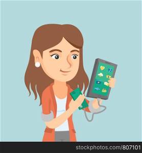Young caucasian woman recharging her smartphone with a mobile phone portable battery. Smiling woman holding a mobile phone and a battery power bank. Vector cartoon illustration. Square layout.. Woman reharging smartphone from portable battery.