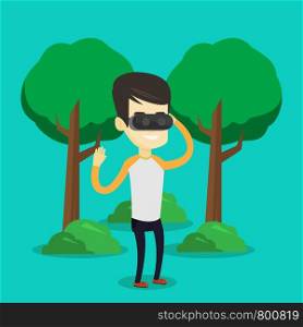 Young cheerful asian gamer wearing virtual reality headset in the park. Happy man using virtual reality glasses and playing videogame in the park. Vector flat design illustration. Square layout.. Man wearing virtual reality headset in the park.
