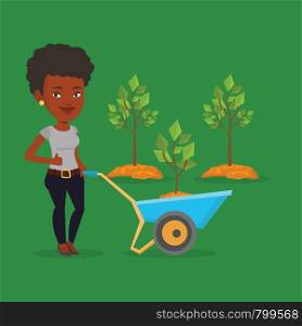 Young gardener pushing wheelbarrow with tree and dirt in the park. An african-american gardener with wheelbarrow on a background of newly planted trees. Vector flat design illustration. Square layout.. Woman pushing wheelbarrow with plant.
