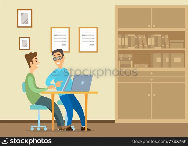 Young man is sitting at a desk with laptop, his colleague is pointing to a screen and giving advice. Office workers discussing work moments. Business meeting and communication. Friendly team work. Young man is sitting at a desk with laptop, his colleague is pointing to a screen and giving advice