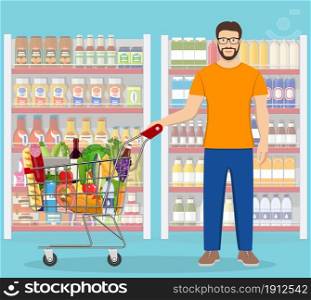 Young man pushing supermarket shopping cart full of groceries. Vector illustration in flat style. Young man shopping for groceries