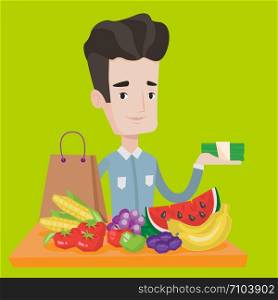 Young man standing at the table with shopping bag, fruits and vegetables on it. Shopper holding stack of money in hand in front of table full of food. Vector flat design illustration. Square layout.. Young man standing at the table with shopping bag