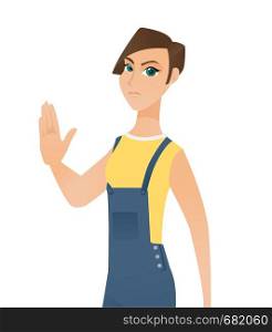 Young serious caucasian white woman in overalls showing a stop hand gesture. Concept of feminism, feminist movement, protest, woman rights. Vector cartoon illustration isolated on white background.. Caucasian white woman showing a stop hand gesture.